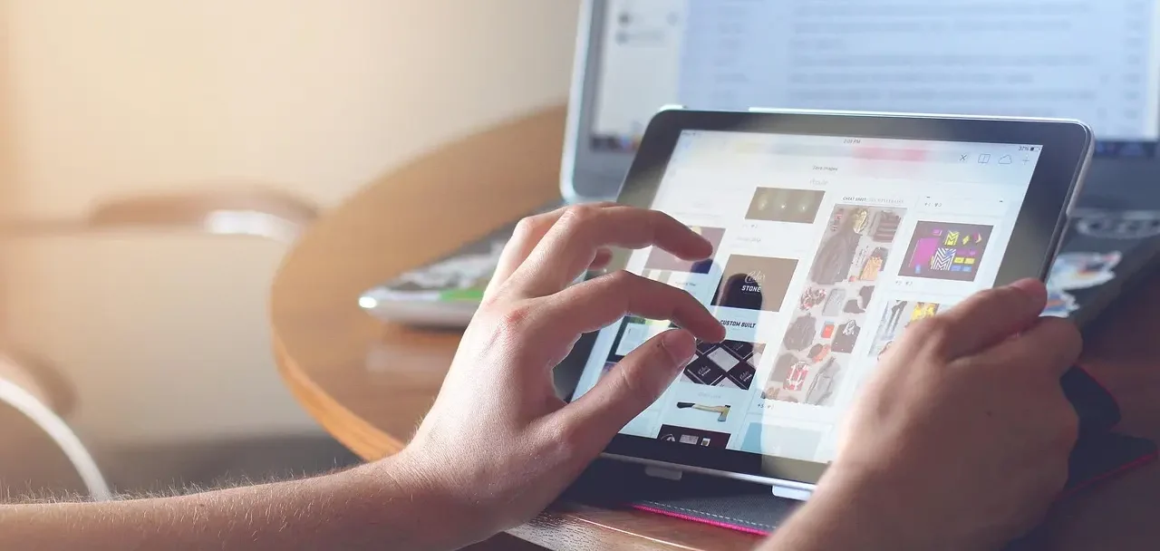 Imagem de uma pessoa usando um tablet e visualizando uma imagem em um site.