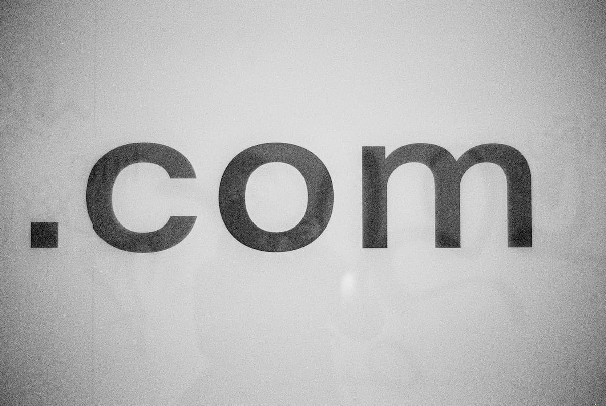 Imagem com o escrito .com de domínio de site.