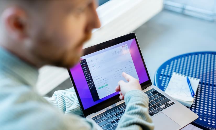 Pessoa analisando métricas de desempenho do site em um notebook, acompanhando indicadores e relatórios.