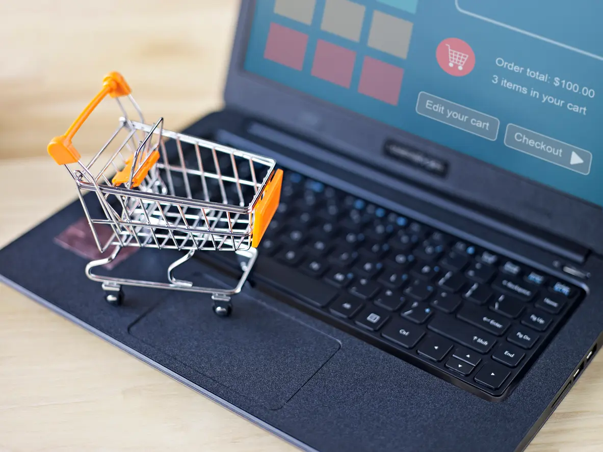 Foto de um mini carrinho de compras em cima de um notebook